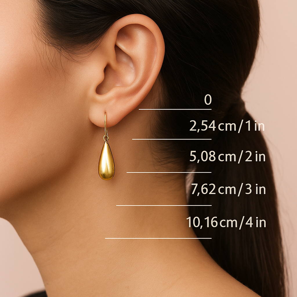 Gold teardrop earring worn by a person with measurement markings on the skin.